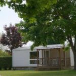 Sur la pelouse mobil-home blanc avec terrasse et arbres du Mobil-Home Cosy 6 Pers avec Terrasse – API-1-52-1949