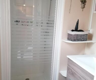 Salle de bain avec cabine de douche et meuble lavabo du Mobil-Home Cosy Climatisé 3 chambres