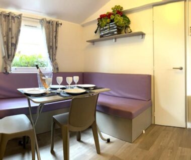 Coin repas avec banquette et fenêtre dans le Mobil-Home Domaine 4 Etoiles de l'Ile d'Or vue mer