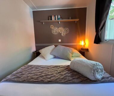 Chambre avec lit et lampe dans le Mobil-Home Domaine 4 Etoiles de l'Ile d'Or vue mer pour 4 personnes