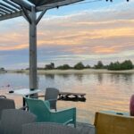 Terrasse couverte avec chaises face au plan d'eau au Mobil Home FI11 Camping les Viviers