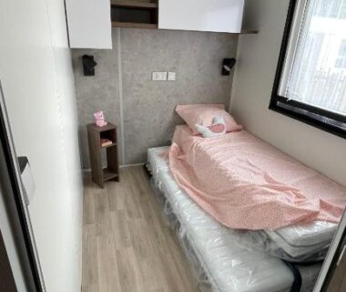 Chambre intérieure avec lit simple et fenêtre dans le Mobil Home FI11 du Camping les Viviers