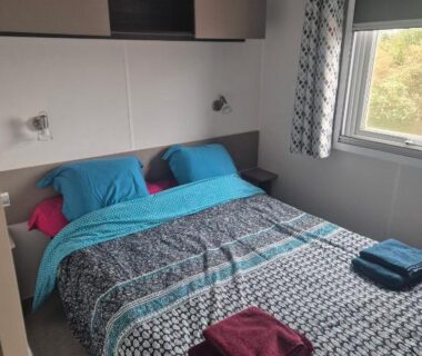 Chambre avec lit double et serviettes dans le Mobil-Home L'Escale MH34 Les Sables du Midi