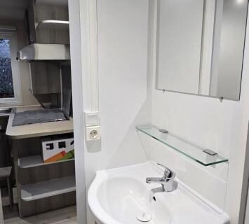Salle de bain avec lavabo et miroir dans le Mobil-Home Le Bois Dormant 87