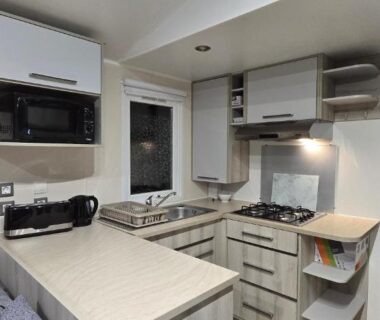 Cuisine équipée avec plan de travail four plaques et coin repas dans le Mobil-Home Le Bois Dormant 87