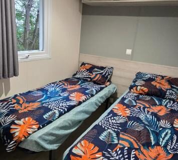Chambre avec deux lits simples et rangements dans le Mobil-Home Le Bois Dormant 87