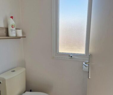 Toilettes compactes avec fenêtre et étagère dans le mobil-home Le Dahlia-MH34
