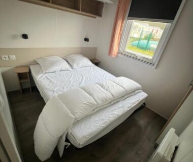 Chambre avec lit double et fenêtre donnant sur la piscine du Mobil Home Litteau Calvados