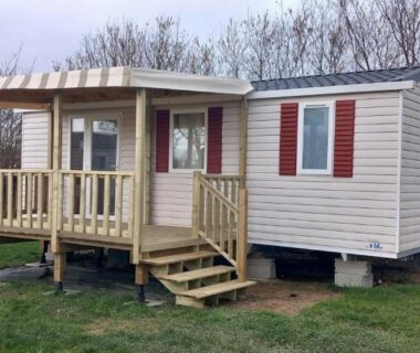 Sur la pelouse mobil home beige avec terrasse en bois au Mobil Home Litteau Calvados
