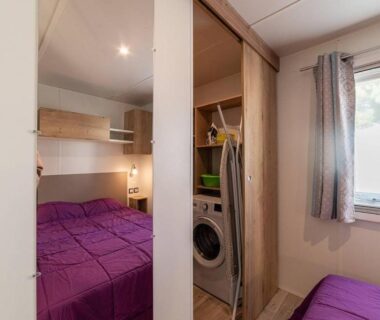 Intérieur chambre avec lits et lave-linge dans le Mobil Home Luxe 3 chambres climatisé Canet en Roussillon