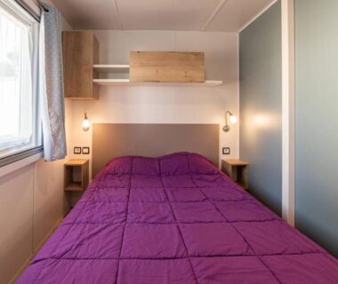 Intérieur chambre avec lit double et couette violette dans Mobil Home Luxe 3 chambres climatisé Canet en Roussillon