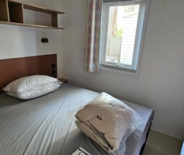 Chambre avec deux lits et fenêtre dans le Mobil Home P171 Le Castellas
