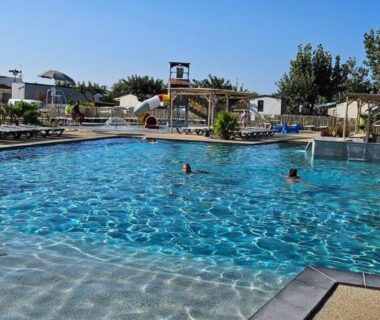 Piscine du camping avec pont et solarium au Mobil Home P171 Le Castellas