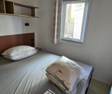 Intérieur chambre avec lits jumeaux et fenêtre dans le mobil home P171 Le Castellas
