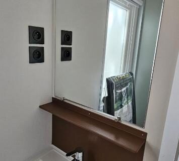 Salle de bain avec lavabo et miroir dans le Mobil Home P171 Le Castellas
