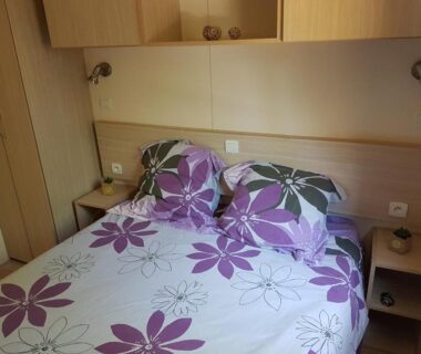Chambre double avec lit à motifs floraux dans le Mobil-Home Port-la-Nouvelle