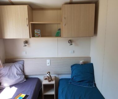 Intérieur mobil-home avec deux lits simples et table de chevet au Mobil-Home Port-la-Nouvelle
