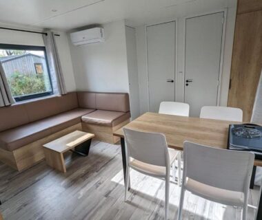 Salon et coin repas avec canapé et table dans le Mobil Home Premium 3 ch Camping 5 Biscarrosse Mayotte F62