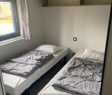 Chambre avec deux lits et fenêtre dans le Mobil Home Premium 3 ch Camping 5 Biscarrosse Mayotte F62