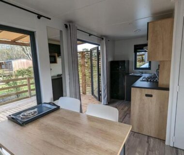 Coin repas avec baie vitrée et terrasse du Mobil Home Premium 3 ch Camping 5 Biscarrosse Mayotte F63