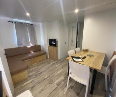 Séjour lumineux avec canapé et table à manger du Mobil-Home Premium 6 couchages
