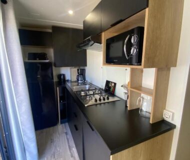 Cuisine équipée avec plaque micro-ondes et réfrigérateur dans le Mobil-Home Premium 6 couchages