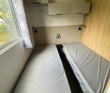 Intérieur mobil-home deux lits simples et rangements dans le Mobil Home Premium Camping Mayotte 5 CLIM TV LV R096