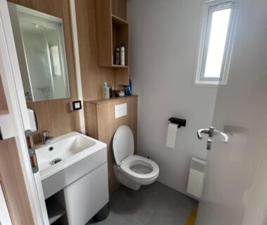 Salle de bain avec lavabo et WC dans le Mobil Home Premium Camping Mayotte 5 CLIM TV LV R096