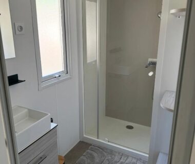 Salle d'eau avec cabine de douche vitrée et lavabo du Mobil Home SIBLU VALRAS PLAGE