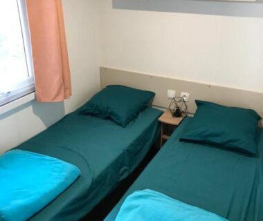 Chambre avec deux lits simples et table de chevet dans le Mobil Home Tous confort a Canet Plage