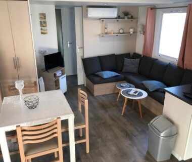 Dans le salon avec canapé et table à manger du Mobil Home Tous confort a Canet Plage