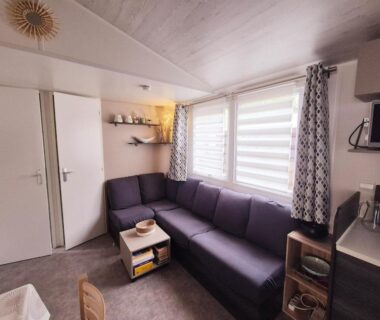 Séjour avec canapé et kitchenette dans le mobil home Vias plage La Carabasse terrasse fermée hors saison