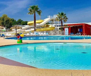 Piscine extérieure avec parasols et toboggan au Mobil-Home Victory Camping Siblu 4****