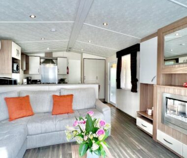 Salon avec canapé et cuisine ouverte dans le Mobil-Home Victory Camping Siblu 4****