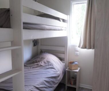 Chambre avec lits superposés et chevet dans le Mobil Home XXL 4 chambres du Camping Country Park