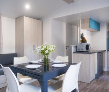 Intérieur coin repas et kitchenette du Mobil Home XXL 4 chambres au Camping Country Park