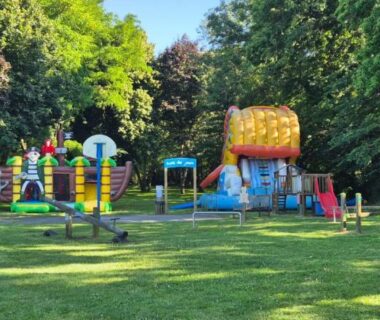 Aire de jeux sur pelouse et structures gonflables au Mobil Home XXL 4 chambres du Camping du Quinquis