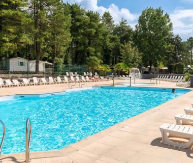 Piscine extérieure bordée de chaises longues au Mobil-Home à Camiers Sainte Cécile
