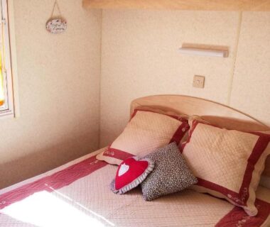 Chambre intérieure avec lit double et rangements dans le Mobil Home à la ferme