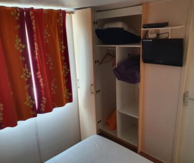 Intérieur chambre avec lit armoire et TV dans le Mobil Home avec spacieuse terrasse à Meschers proche de Royan