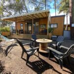 Terrasse en bois avec fauteuils autour d'une table au Mobil Home camping La Civelle