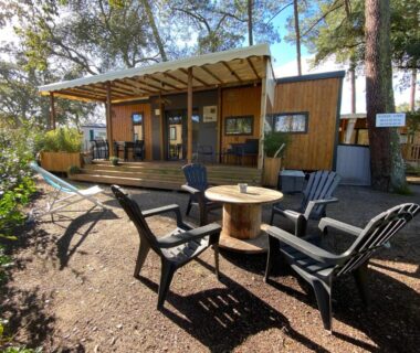 Terrasse en bois avec fauteuils autour d'une table au Mobil Home camping La Civelle