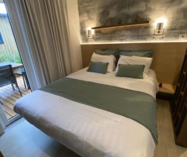 Chambre avec lit double et baie vitrée dans le Mobil Home camping La Civelle