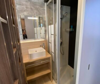 Salle d'eau avec cabine de douche et lavabo dans le mobil home Camping La Civelle
