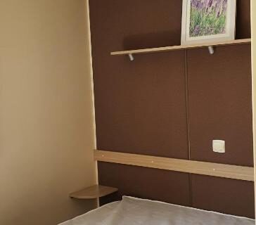 Intérieur de chambre avec lit et étagère dans le Mobil Home climatisé 6 personnes