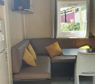 Coin salon avec banquette et coussins dans le Mobil Home climatisé 6 personnes