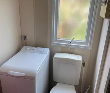 Toilettes et lave-linge sous la fenêtre dans le mobil home du camping le Montourey