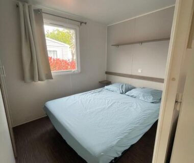 Chambre avec lit double et fenêtre donnant sur l'extérieur du Mobil Home de Marine