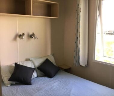 Chambre avec lit double coussins et fenêtre du Mobil Home pour 6 personnes climatisé à quelques minutes des plages