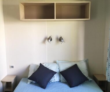 Chambre avec lit double et lampes de lecture dans le mobil home pour 6 personnes climatisé